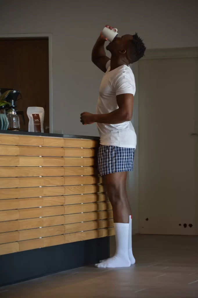 Mand i undertøj drikker kaffe